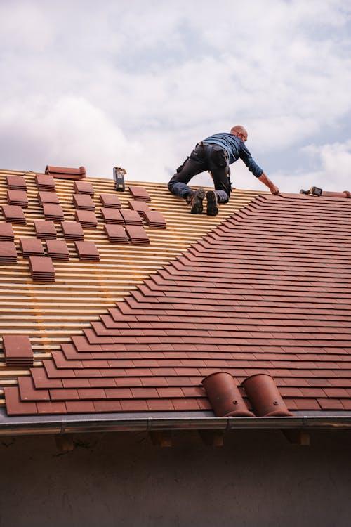 A roofer installing tiles