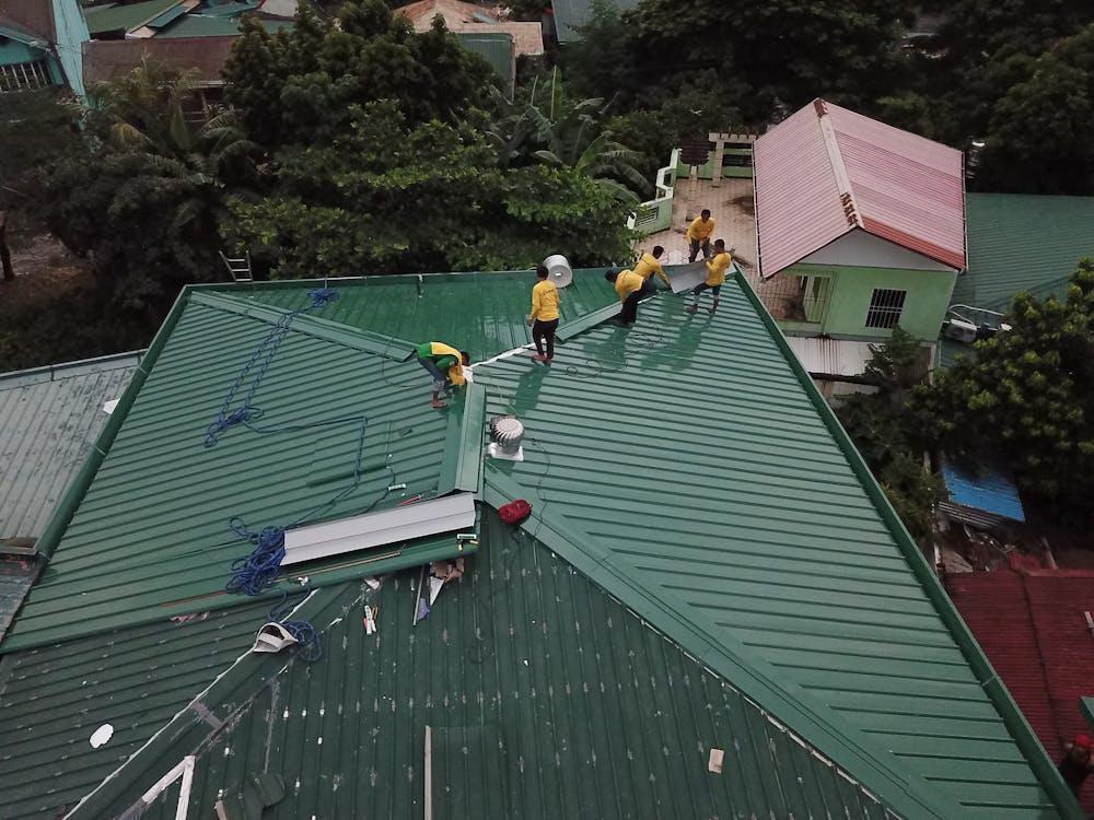 Roofers working on a metal roof