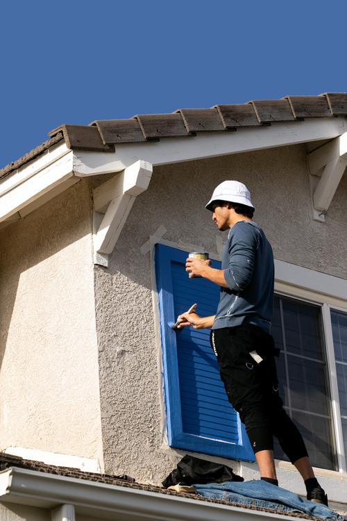A painter painting the exterior walls