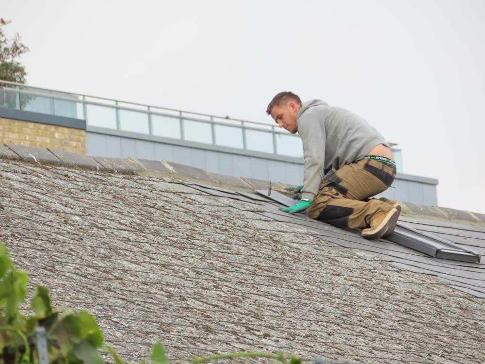 A professional putting tiles on a roof